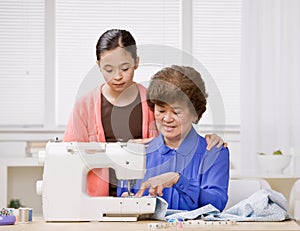 Granddaughter and grandmother use sewing machine