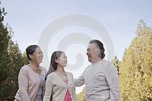 Granddaughter with grandparents walking in the park