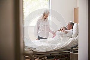 Granddaughter Hugging Grandfather On Family Hospital Visit photo