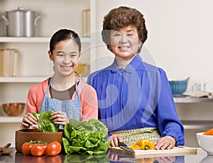 Granddaughter preparing salad with grandmother