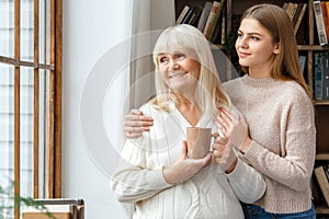 Granddaughter taking care of her retired grandmother standing together