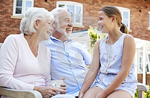 Granddaughter Talking With Grandparents During Visit To Retirement Home