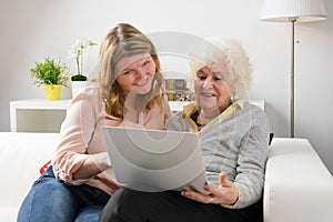 Granddaughter teaching grandma how to use computer