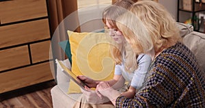 Granddaughter teaching grandmother how to use tablet . Teen girl and senior woman have leisure time together. Family