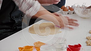 Granddaughter whit grandmother preparing delicious gingerbread dessert using cooking shape