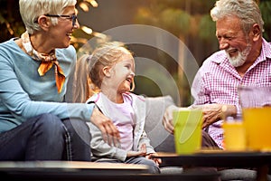 Grandfather amusing his granddaughter, laughing, enjoying