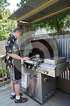 Grandfather Barbecuing On The Grill