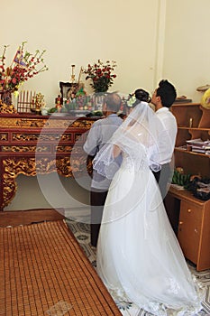 Grandfather with bride and groom are burned incense to forefather in wedding day photo