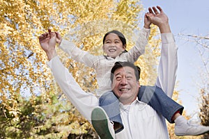 Grandfather Carrying Granddaughter on His Shoulders