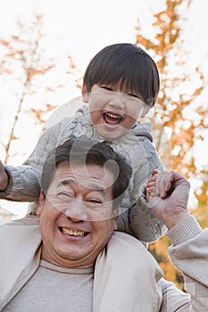 Grandfather Carrying Grandson on His Shoulders