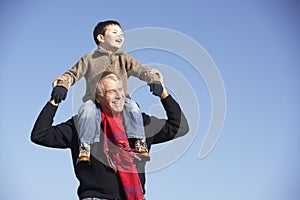Grandfather Carrying Grandson On His Shoulders photo