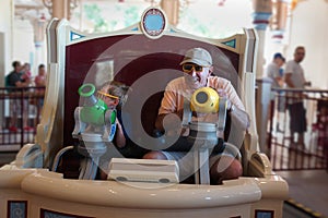 Grandfather and child on carnival ride amusement park