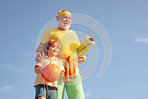 Grandfather and child is doing sport outdoors. Happy fit senior man exercising. Healthy life and sport concept. Be in