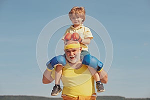 Grandfather and child fighting poses. Grandpa and little child boy in boxing stance doing exercises with boxing gloves.