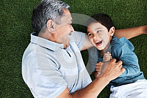 Grandfather, child and laughing on grass having fun with love and grandparent care. Laugh, happy kid from above and