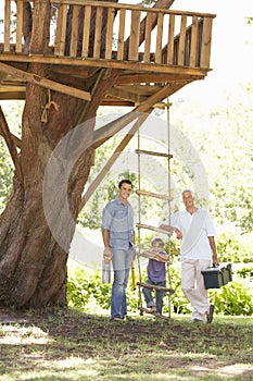 Grandfather, Father And Son Building Tree House Together