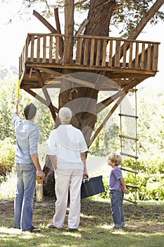 Grandfather, Father And Son Building Tree House Together
