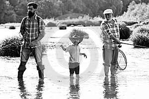 Grandfather, father and son are fly fishing on river. Anglers. Happy fisherman with fishing rod. Happy grandfather and