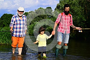 Grandfather, father and son are fly fishing on river. Fly fisherman using fly fishing rod in river. 3 men fishing on