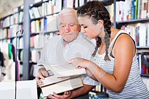 Grandfather with girl are reading books