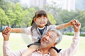 Grandfather Giving Granddaughter Ride On Shoulders photo