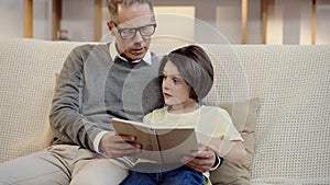 grandfather in glasses reading book to