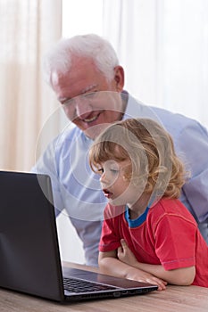 Grandfather and grandchild using laptop