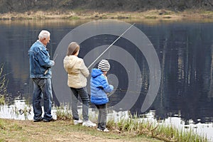 Grandfather and grandchildren are fishing.