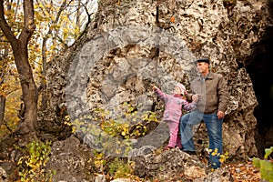 Grandfather and granddaughter are near the cavern