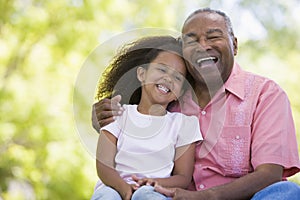 Grandfather and granddaughter outdoors smiling photo