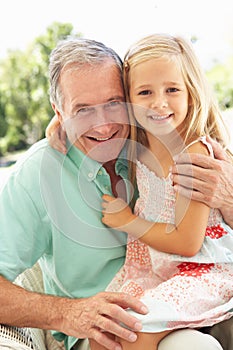 Grandfather With Granddaughter Relaxing Together