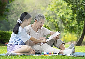 grandfather and granddaughter spend free time together by drawing