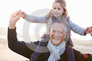 Grandfather And Granddaughter Walking On Winter Beach photo