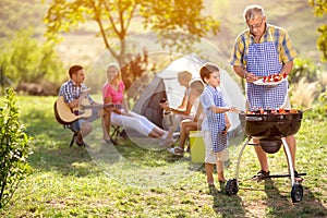 Grandfather and grandson at barbecue grill