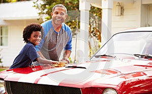 Grandfather And Grandson Cleaning Restored Classic Car