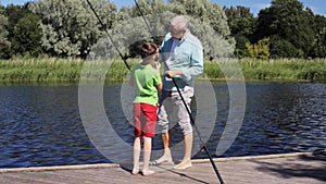Grandfather and grandson fishing on river berth 1