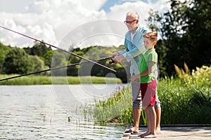 Grandfather and grandson fishing on river berth