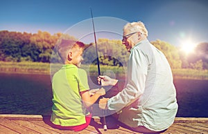 Grandfather and grandson fishing on river berth