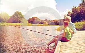 Grandfather and grandson fishing on river berth