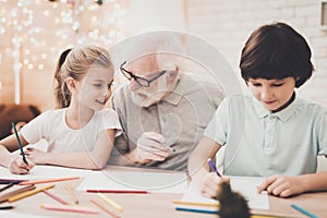 Grandfather, grandson and granddaughter at home.