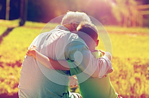 Grandfather and grandson hugging outdoors