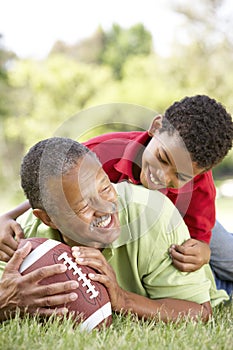 Grandfather And Grandson In Park With Football