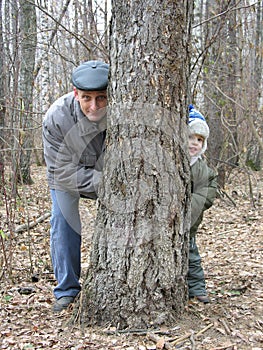 Grandfather and grandson play hide-and-seek photo