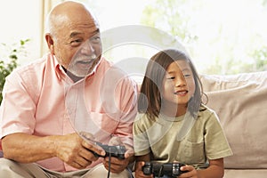 Grandfather And Grandson Playing Computer Game At