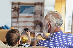 Grandfather and grandson are playing video games