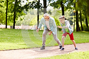 Grandfather and grandson racing at summer park