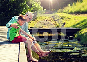 Grandfather and grandson sitting on river berth