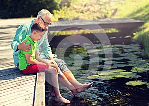 Grandfather and grandson sitting on river berth