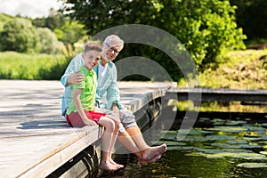 Grandfather and grandson sitting on river berth