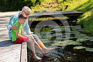 Grandfather and grandson sitting on river berth